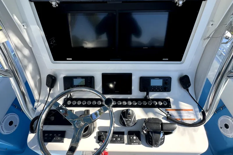 Slide: The Image of 2023 Contender 30 ST boat dashboard with steering wheel and electronic controls. - 20