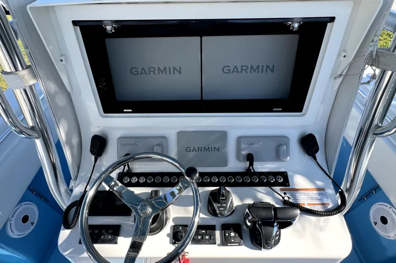 Slide: The Image of 2023 Contender 30 ST boat dashboard with Garmin navigation displays and controls. - 21