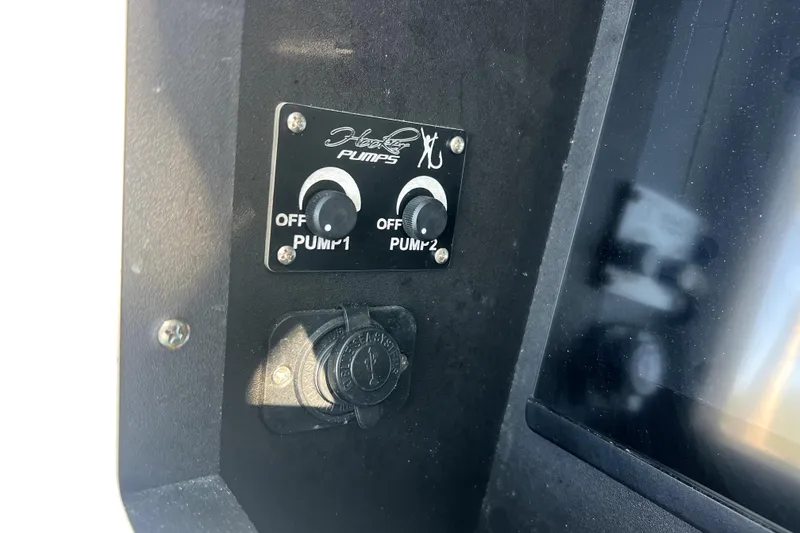Slide: The Image of Control panel of 2023 Contender 30 ST boat with pump switches and power outlet. - 22