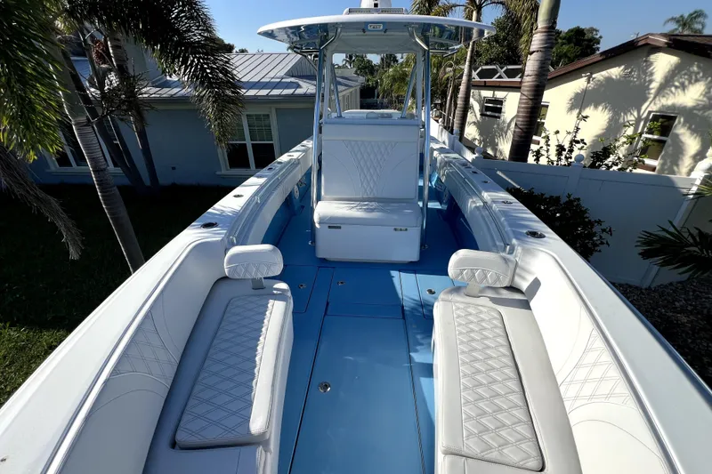 Slide: The Image of 2023 Contender 30 ST boat with sleek seating and modern design in a tropical setting. - 28