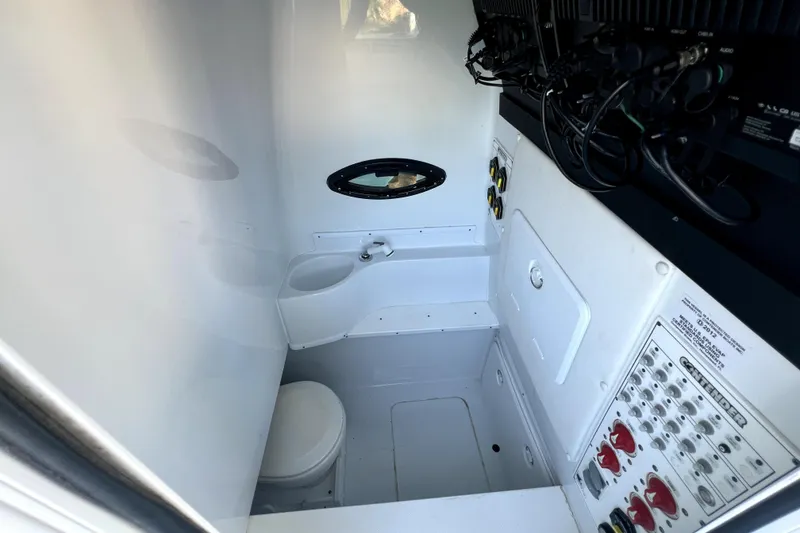 Slide: The Image of Interior of 2023 Contender 30 ST boat showing compact bathroom and control panel. - 34