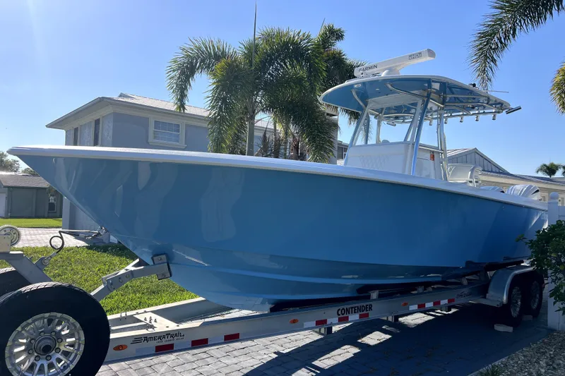 Slide: The Image of 2023 Contender 30 ST boat on trailer, parked near palm trees and houses. - 42