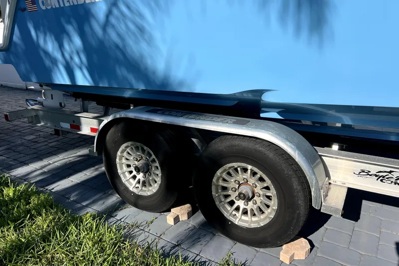 Slide: The Image of Trailer of 2023 Contender 30 ST boat on paved driveway, secured with wheel chocks. - 46