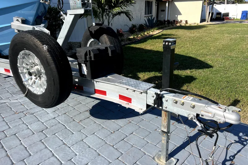 Slide: The Image of Trailer hitch of a 2023 Contender 30 ST boat on a paved driveway. - 48