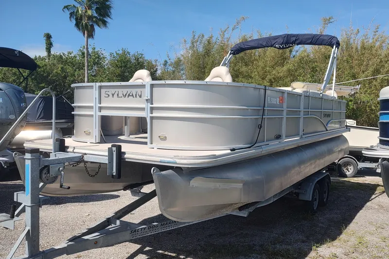 Slide: The Image of 2016 Sylvan Mirage Fish 8522 Party Fish pontoon boat on trailer, parked outdoors. - 1