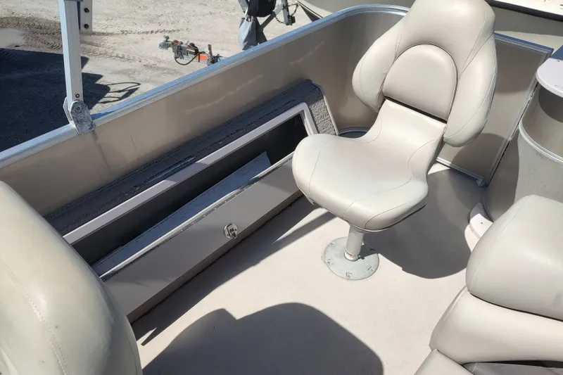 Slide: The Image of 2016 Sylvan Mirage Fish 8522 Party Fish boat interior with beige seating and storage compartment. - 5