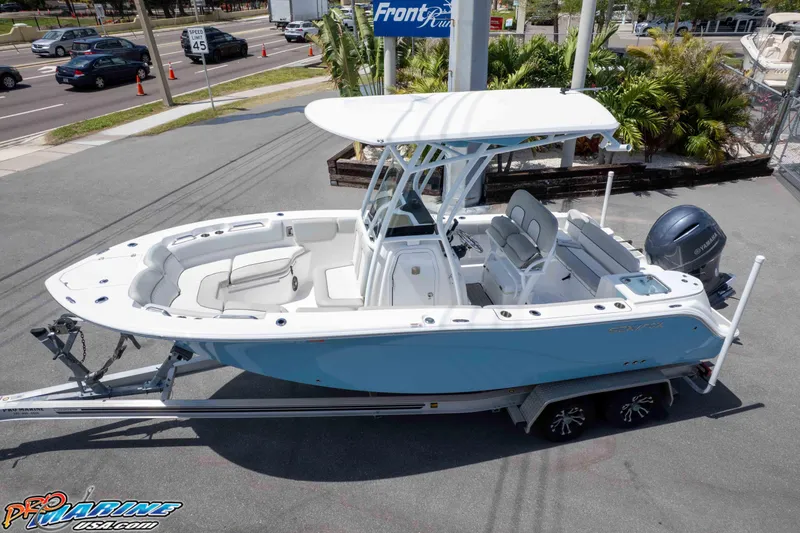 Slide: The Image of 2021 Sea Fox 228 Commander boat on trailer, parked near road with traffic and greenery. - 42