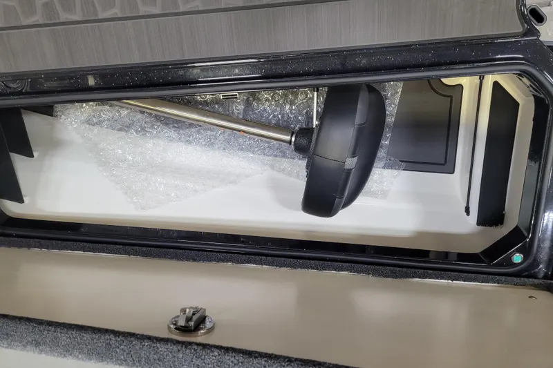 Slide: The Image of 2025 Ranger Z520R Cup-Equipped storage compartment with steering wheel and bubble wrap. - 14