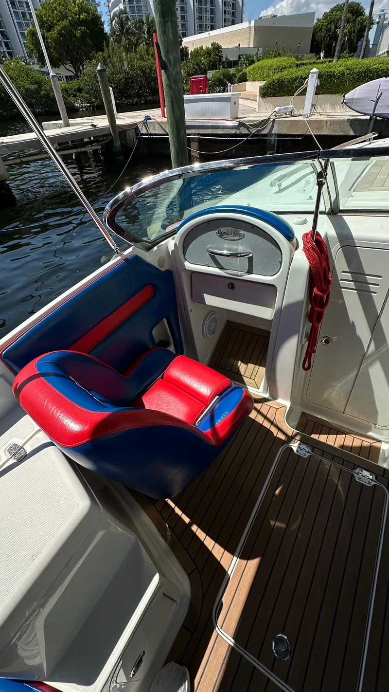 Slide: The Image of 2009 Chris-Craft Corsair 25 boat interior with red and blue seating, docked by the water. - 11
