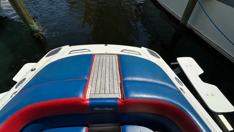 Slide: The Image of 2009 Chris-Craft Corsair 25 boat with blue and red seating, docked on water. - 15
