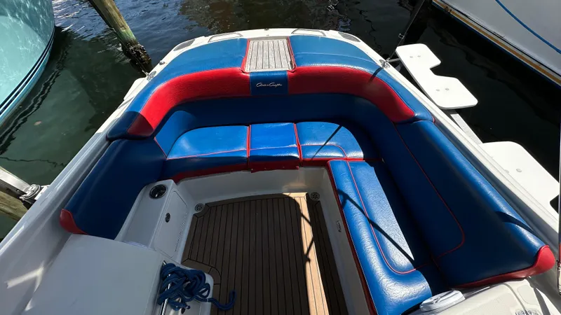 Slide: The Image of 2009 Chris-Craft Corsair 25 boat with blue and red seating, docked by the water. - 16