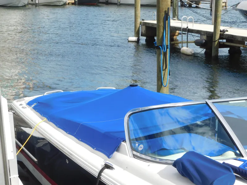 Slide: The Image of 2009 Chris-Craft Corsair 25 boat docked with blue cover, marina background. - 26