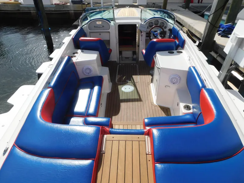 Slide: The Image of 2009 Chris-Craft Corsair 25 boat with blue and red seating, docked at marina. - 28