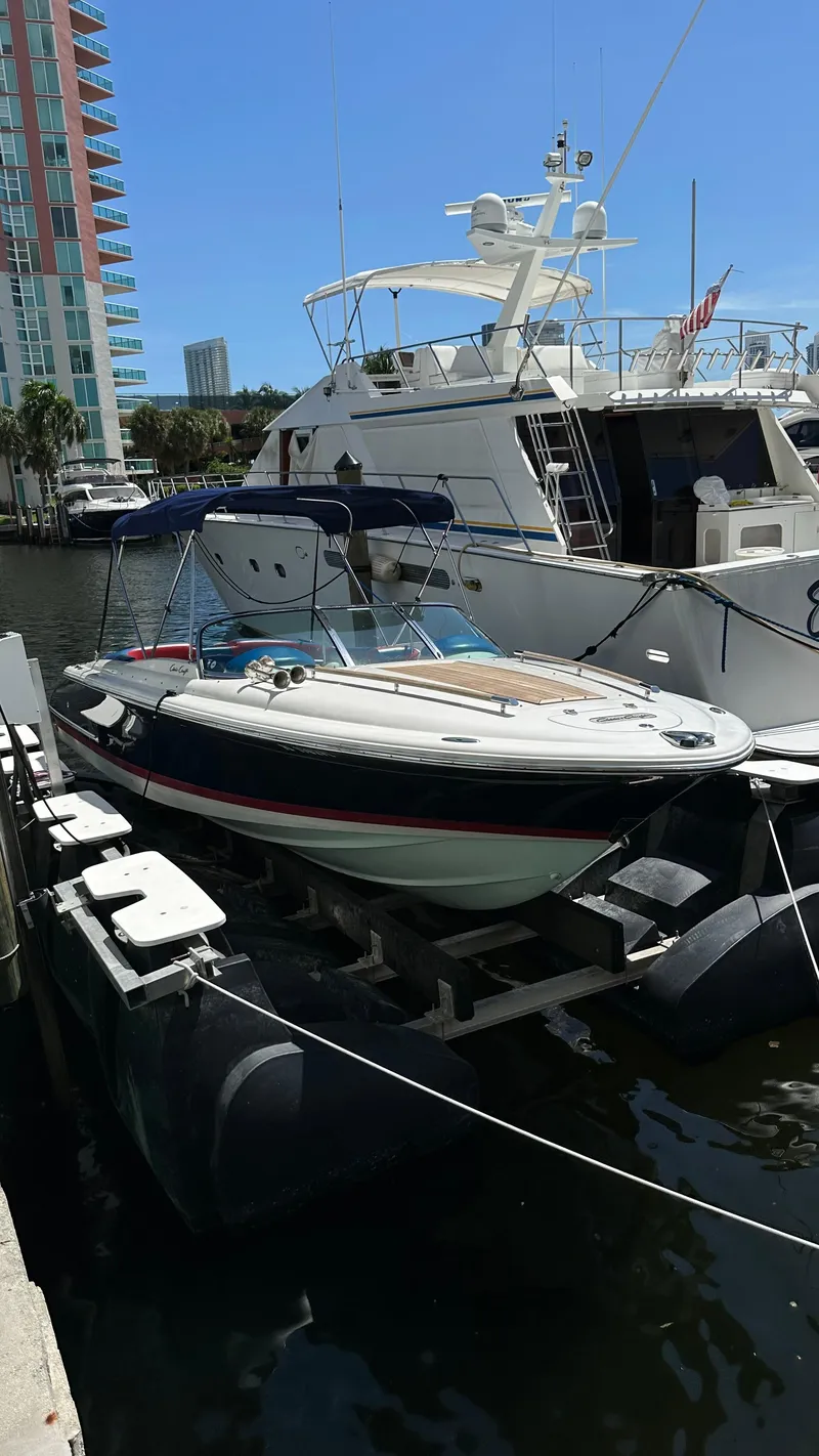 Slide: The Image of 2009 Chris-Craft Corsair 25 boat docked at marina, sunny day, luxury yachts in background. - 3