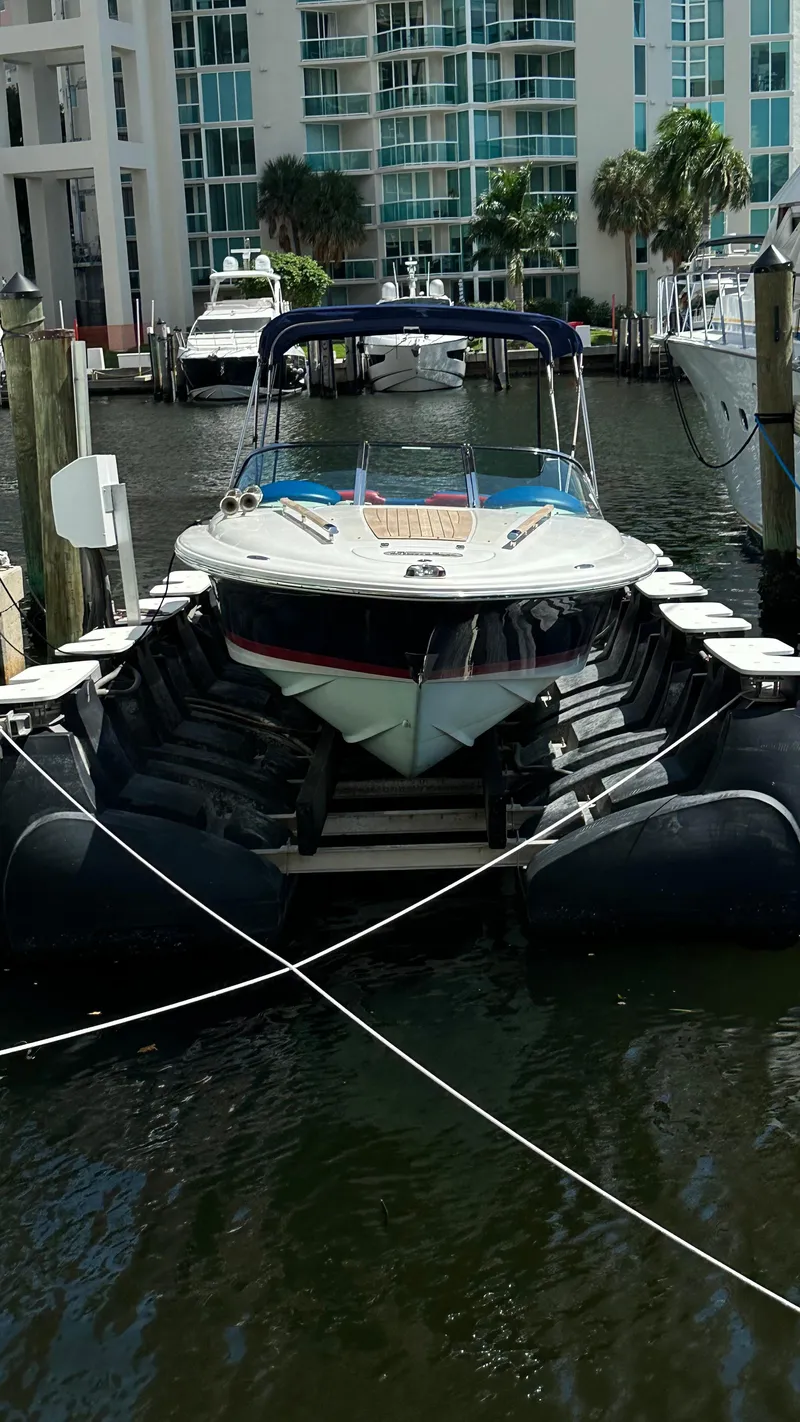 Slide: The Image of 2009 Chris-Craft Corsair 25 docked in a marina with surrounding boats. - 6