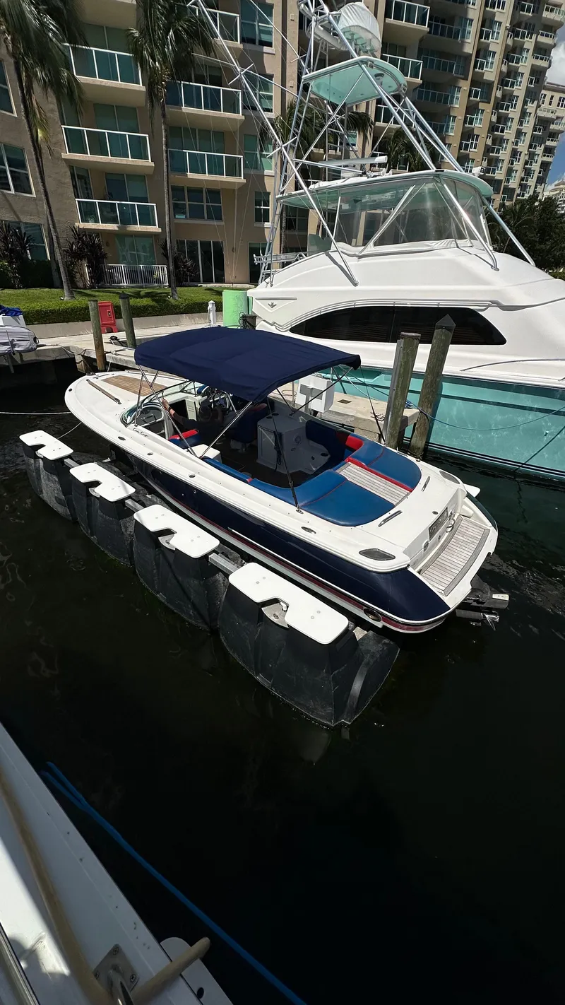 Slide: The Image of 2009 Chris-Craft Corsair 25 boat docked near waterfront buildings. - 7