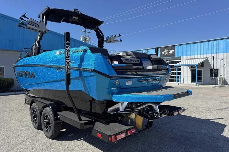 Slide: The Image of 2026 Supra SL boat in vibrant blue on a trailer outside a dealership. - 3