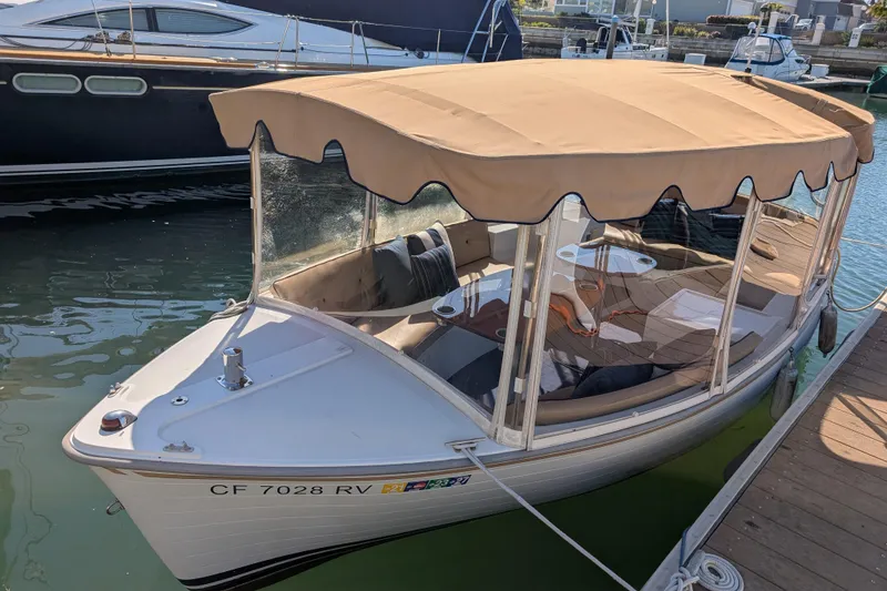 The Image of 2013 Duffy Snug Harbor 18 electric boat docked with canopy and seating. - 1
