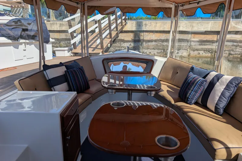 Slide: The Image of Interior of 2013 Duffy Snug Harbor 18 boat with cushioned seating and striped pillows. - 13