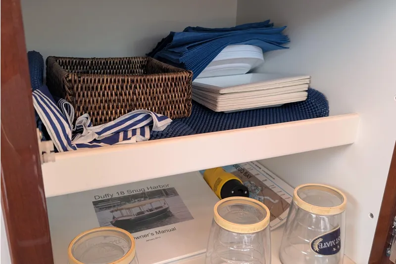 Slide: The Image of Cabinet with Duffy Snug Harbor 18 manual, wicker basket, and glassware. - 14