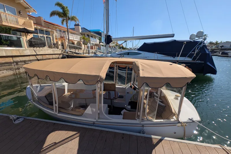 Slide: The Image of 2013 Duffy Snug Harbor 18 electric boat docked in sunny marina setting. - 4