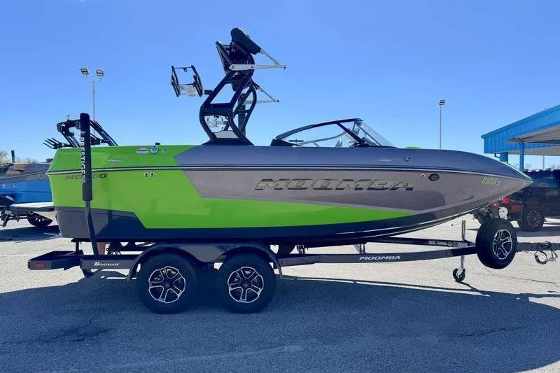 Slide: The Image of 2021 Moomba Mondo boat with vibrant green and gray design on a trailer. - 2