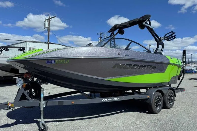 Slide: The Image of 2021 Moomba Mondo boat on trailer, featuring a sleek green and gray design. - 3