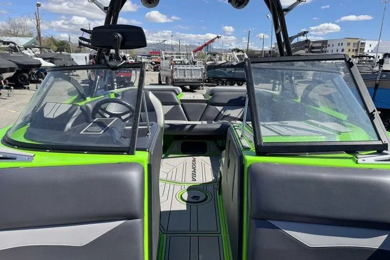 Slide: The Image of 2021 Moomba Mondo boat with green and gray interior, parked outdoors. - 6