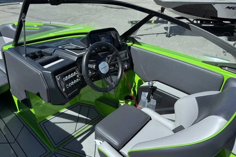 Slide: The Image of 2021 Moomba Mondo boat interior with green accents and modern dashboard design. - 9