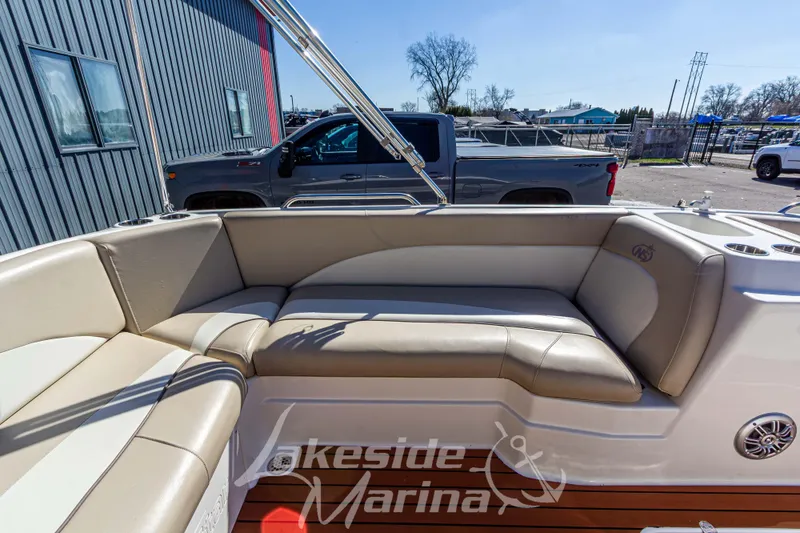 Slide: The Image of 2017 NauticStar 193 SC boat interior with beige seating, parked near a marina. - 14