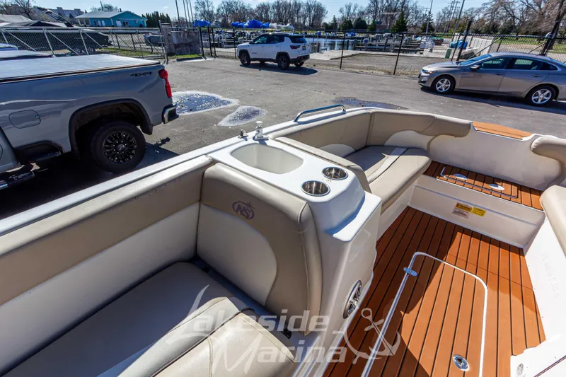 Slide: The Image of 2017 NauticStar 193 SC boat interior with seating and cup holders, parked near vehicles. - 19