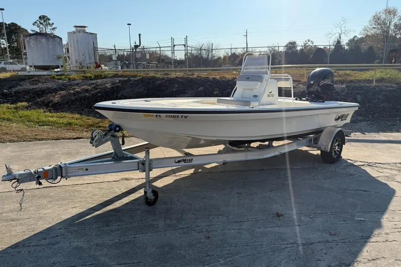 Slide: The Image of 2024 Mako 18 LTS boat on trailer, parked outdoors in sunny setting. - 0