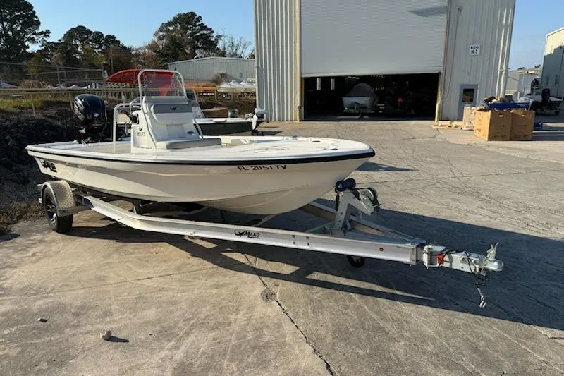 Slide: The Image of 2024 Mako 18 LTS boat on trailer outside industrial building. - 1