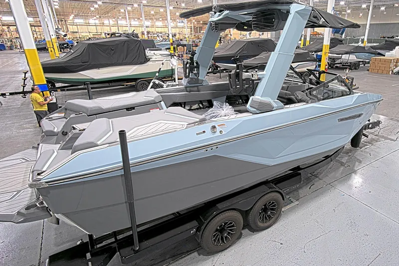 Slide: The Image of 2025 Nautique Super Air Nautique G23 Paragon boat in a showroom, side view. - 3