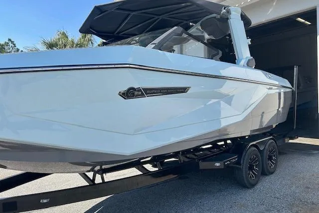 Slide: The Image of 2025 Nautique Super Air Nautique G23 Paragon boat on trailer, sleek design, outdoor setting. - 7