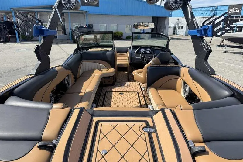 Slide: The Image of 2022 MB Sport B52 boat interior with tan and black seating, open layout, and modern design. - 13