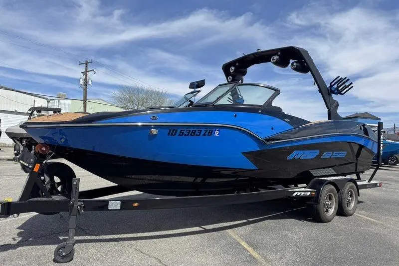 Slide: The Image of 2022 MB Sport B52 boat in blue and black on a trailer, parked outdoors. - 14