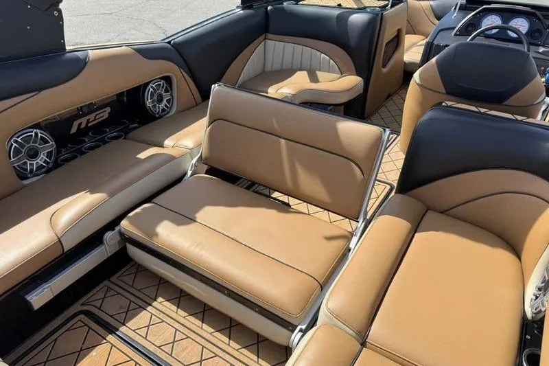 Slide: The Image of 2022 MB Sport B52 boat interior with tan and black seating, featuring premium sound system. - 2