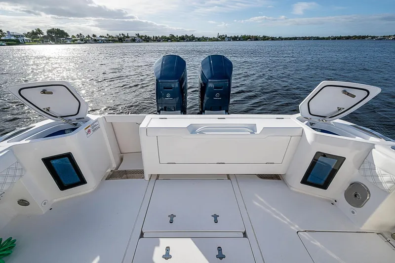 Slide: The Image of 2024 Intrepid 41 Valor boat deck with open storage compartments and twin engines on water. - 18