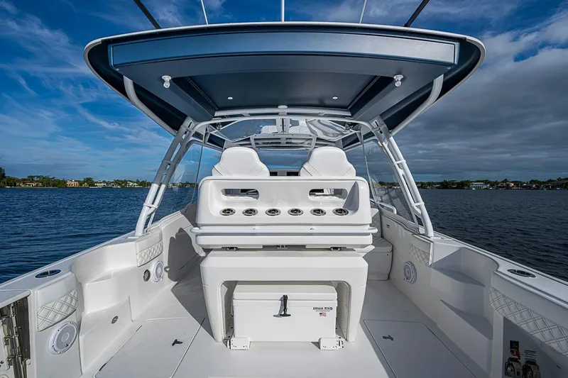Slide: The Image of 2024 Intrepid 41 Valor boat interior with helm station, on a calm water backdrop. - 23