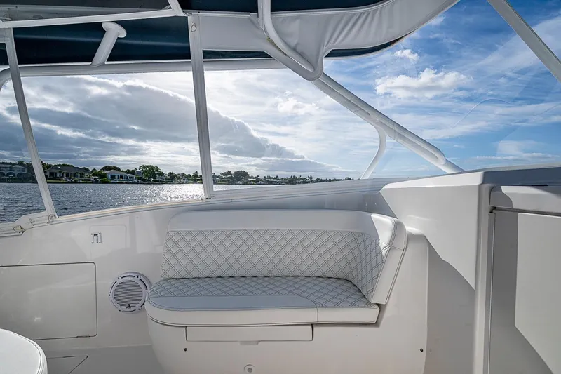 Slide: The Image of 2024 Intrepid 41 Valor boat interior with cushioned seating, overlooking serene waters. - 29