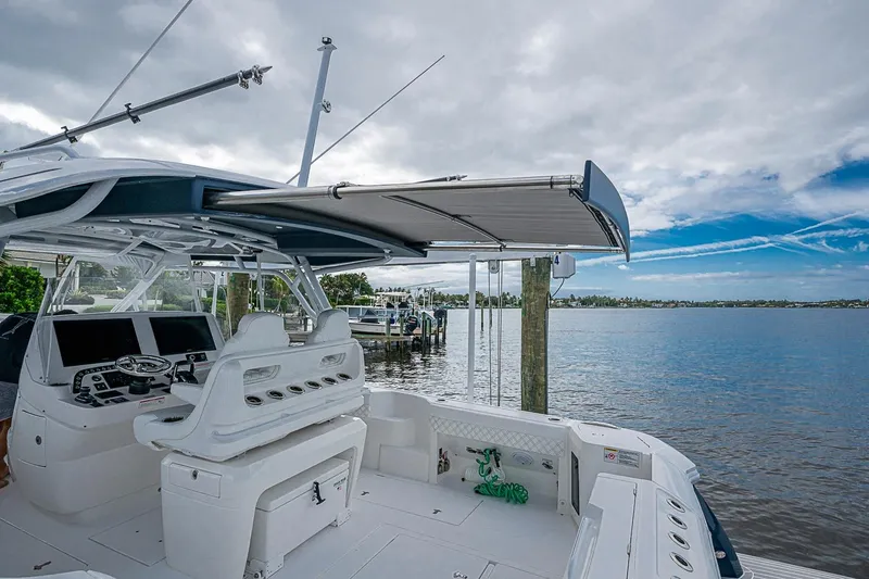 Slide: The Image of 2024 Intrepid 41 Valor boat with helm and seating, docked by a serene waterfront. - 42