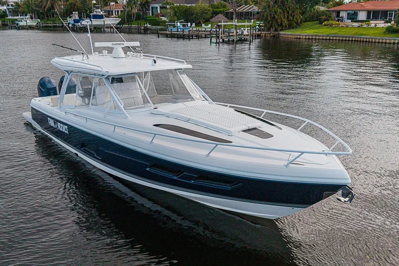 Slide: The Image of 2024 Intrepid 41 Valor boat on calm water near residential docks. - 5