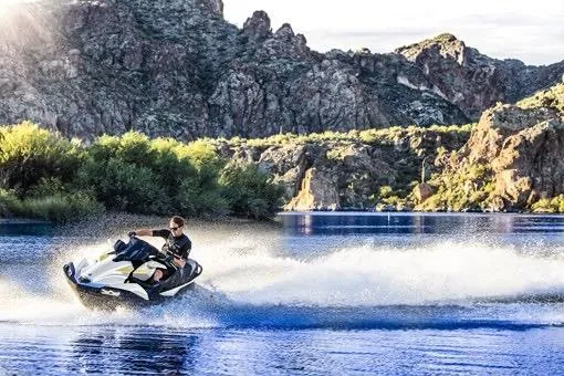 Slide: The Image of 2026 Kawasaki ULTRA 160LX jet ski speeding on a scenic lake with rocky backdrop. - 7