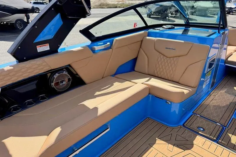 Slide: The Image of 2022 MasterCraft XT22 boat interior with tan seating and blue accents. - 10