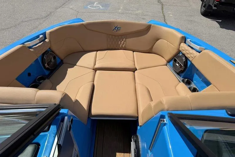 Slide: The Image of 2022 MasterCraft XT22 boat interior with tan seating and blue exterior. - 13