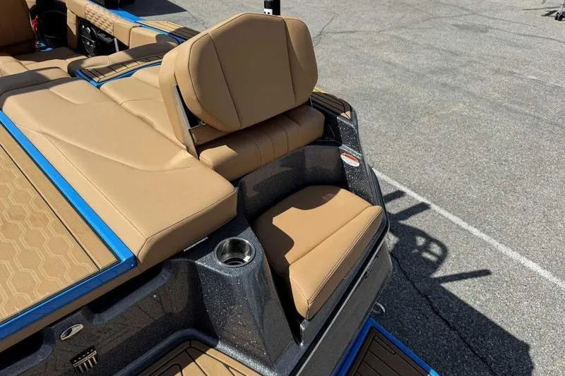 Slide: The Image of 2022 MasterCraft XT22 boat interior with tan seating and cup holder. - 3