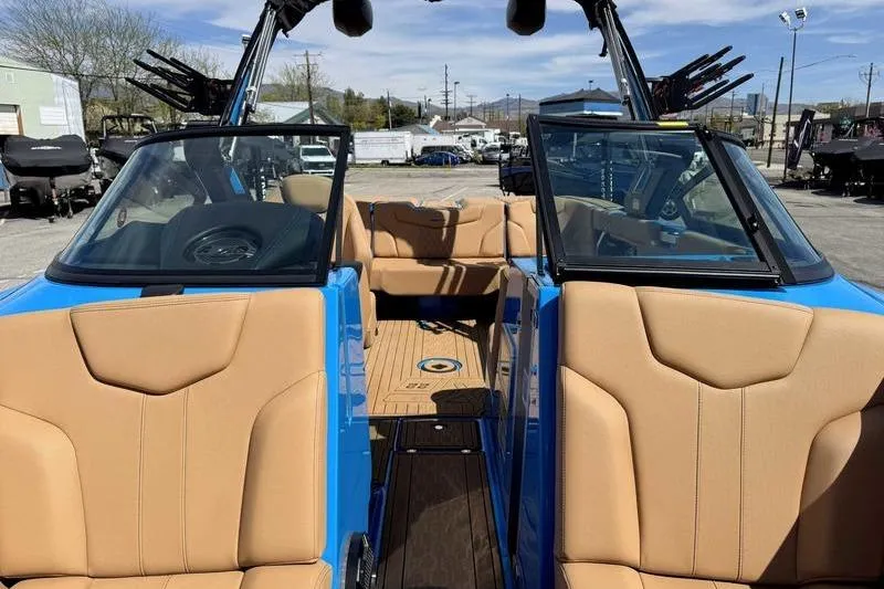 Slide: The Image of 2022 MasterCraft XT22 boat interior with tan seats and blue exterior. - 6