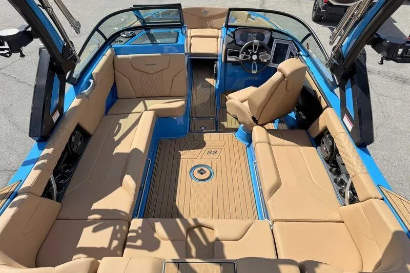 Slide: The Image of 2022 MasterCraft XT22 boat interior with tan seating and blue accents. - 7
