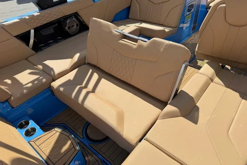 Slide: The Image of 2022 MasterCraft XT22 boat interior with tan seating and blue accents. - 8